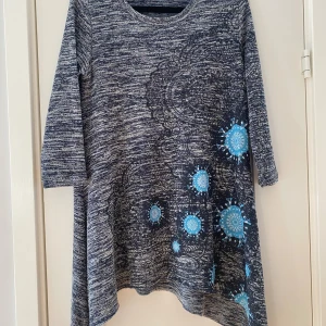 Blå mönstrad tunika Desigual S - Unik blåmelerad tunika från Desigual i storlek S med coola blå mandala-liknande mönster framtill och baktill. Tunikan har trekvartsärm och är i mjukt stickat material. Passformen är loose.                                  Mått Över bröstet: ca 50 cm Längd från axeln och ner: ca 76 cm  Kommer från ett djur och rökfritt hem. 
