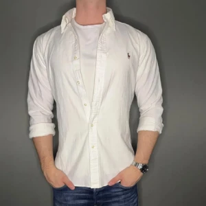Vit Ralph lauren skjorta - Hej säljer nu min fina Ralph lauren skjorta i storlek M. Den är i bra skick och kommer vara otroligt snygg nu i vår och framåt sommaren. Nypris cirka 1600kr! Vi kommer att sälja liknande produkter nu i vår och närmare sommar så glöm inte följa profilen!🌊🍾 27