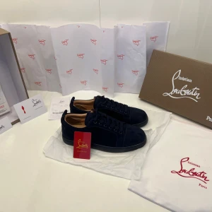 Mörkblå sneakers från Christian Louboutin - Mörkblå mocka skor från Christian loubitins i storlek 42. Skorna är i ett nytt skick utan användning. Du får med alla tillbehör. Skriv för någon annan info. Köp dom för 1599 (100kr+) så får du med ett valfritt bälte inne på mitt kontakt av ditt val 
