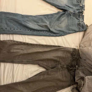 Två par jeans från Jack & Jones, 32/34 - Säljer två par jeans från Jack & Jones i storlek 32/34. Ett par är ljusblå med klassisk denimlook och kontrastsömmar, det andra paret är gråa med en tvättad finish. Båda har rak passform och femficksdesign. Perfekta för dig som gillar stilrena och bekväma jeans.