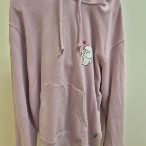 Rosa hoodie Uniqlo Line Friends XS - Säljer en ljuslila hoodie från Uniqlo x Line Friends i storlek XS. Tröjan har en söt kanin- och hjärt-tryck på bröstet, huva med snörning och stor magficka. 