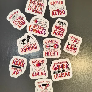 12 st Gaming Stickers - 12 st Färgglada stickers med gaming-tema, perfekta för att dekorera laptops, konsoler eller tillbehör. Innehåller motiv som retro-gaming, XP, och roliga gamer-citat. Alla stickers är i nyskick.