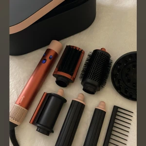 Dyson Airwrap  - Dyson Airwrap slutsåld i koppar/roséguld med flera stylingtillbehör. Inkluderar borstar, locktillbehör och förvaringsbox. Säljer alla munstycken och boxen, inte själva fönhandtaget eller största rundborsten, men det går att köpa på exempelvis SHEIN för 200! 