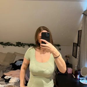 Ljusgrön topp från Gina Tricot XS - En ljusgrön, tight topp från Gina Tricot i storlek XS och är från basic kollektionen. Toppen har rund, djup ringning och korta ärmar. Tillverkad i mjukt och stretchigt material som sitter snyggt mot kroppen. 