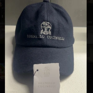 Brunello Cucinelli keps - Brunello Cucinelli keps i marinblå nyans.  Storlek: Unisex - Skick: 8,7/10 - Kepsen är lite smutsig.  Vad som ingår: Keps & etikett. 2899 SEK.
