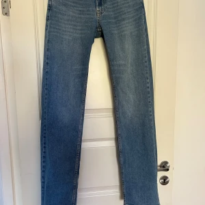 Blå raka jeans från Nelly - Snygga blå jeans från Nelly med klassisk femficksdesign och raka ben. Modellen ”low waist straight leg jeans” i denim blue. 