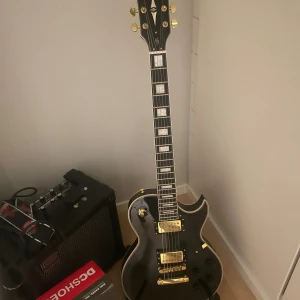Harley benton elgitarr  - OBS :SÄG TILL MIG OM DU VILL KÖPA för de är ett stort föremål och ska skickas på ett annat sätt.Harley benton elgitarr i svart med gulddetaljer. Gitarren är i mycket fint skick utan synliga repor eller slitage.