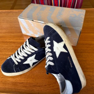 Marinblå Golden goose sneakers - Riktigt feta marinblåa golden goose sneakers I 8/10 skick. Skorna är väldigt trendiga och bidrar till riktigt fet och en lyxig look. Priset är inte hugget i sten så kom med prisförslag!