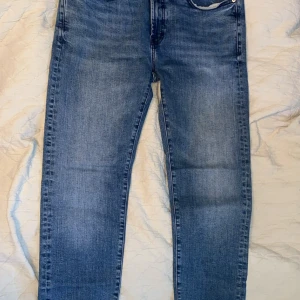 Blå slim fit jeans från Dressmann - Säljer ett par blå jeans från Dressmann i slim fit-modell. Jeansen har klassisk femficksdesign, normalhög midja och är tillverkade i mjukt denimtyg. Perfekta för dig som gillar en smalare passform och stilren look.