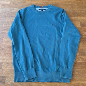 Grön tröja Tommy Hilfiger M - Snygg grön tröja från Tommy Hilfiger i storlek M. Klassisk rund halsringning, diskret logga på bröstet och ribbade muddar vid ärmslut och nederkant. Perfekt för lager-på-lager och enkel att matcha med jeans eller chinos. Skulle säga att den är mindre i storleken så passar mer S men funkar M också