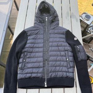 Svart Moncler pufferjacka med huva - Snygg svart pufferjacka från Moncler med stickade ärmar och quiltad front. Jätte fin och snygg nästa helt ny jätte fint skick storlek s passar m