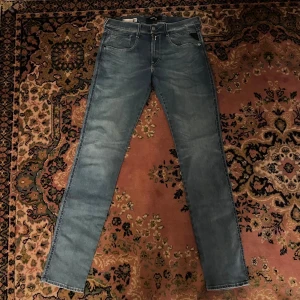 Replay Anbass ljusblå slim jeans 31/34 - Säljer ett par Replay Anbass jeans i ljusblå tvätt med klassisk femficksdesign och snygga kontrastsömmar. Jeansen har slim fit-passform och raka ben, tillverkade i mjukt jeanstyg för en bekväm känsla. Perfekta för dig som gillar stilrena och moderna jeans. Midja 41cm längd 109cm (46)