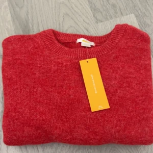 Röd stickad kortärmad tröja Gina Tricot - Superfin röd stickad tröja från Gina Tricot Young med korta ärmar och rund halsringning. Tröjan har en mjuk och mysig känsla, perfekt för lager-på-lager och snygg till jeans eller kjol. Enkel och stilren design som passar till många outfits. Storlek 146-152