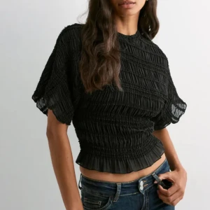 Svart croppad blus med volang - Blus från Nelly. Aldrig använd. Prislapp kvar!