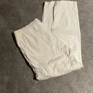 Linnebyxor från Selected Homme - Snygga vita byxor från Selected Homme med elastisk midja för skön passform. Byxorna har en rak och avslappnad siluett, perfekta för en clean och fräsch look. Tillverkade i mjukt bomullsmaterial som känns bekvämt hela dagen.