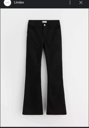 Svarta bootcut jeans från Lindex - Snygga svarta jeans från Lindex med klassisk bootcut-passform. Byxorna har fem fickor, knapp och dragkedja fram samt bälteshällor. Materialet är mjukt och stretchigt jeans, vilket gör dem bekväma att bära hela dagen. Avklippta längst ner någon cm.