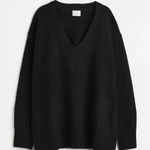 Svart stickad v-ringad tröja - Mysig svart stickad tröja från H&M, med v-ringad hals och lång ärm. Tröjan har en loose passform och är perfekt för lager-på-lager under kyliga dagar. Enkel och stilren design som funkar till många olika outfits.