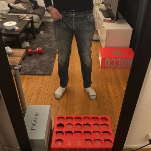 Jacob cohens  - Säljer ett par Jacob cohens jeans i mörkblå tvätt med snygga slitningar och detaljerade sömmar. Modellen är tapered med normal passform och klassisk femficksdesign. Jeansen har dragkedja och knappstängning samt diskreta slitningar vid knäna för en cool look.