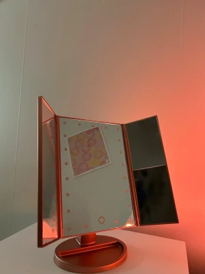 Sminkspegel med ledlampa  - Rosé färgad sminkspegel från UNIQ  med 4 olika speglar och belysningar 
