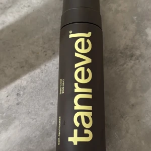 Tanrevel Self-tan Mousse Dark Cool - Tanrevel Self-tan Mousse i färgen Dark Cool, 200 ml. Kommer i en stilren brun flaska med stor gul text. Perfekt för att få en solkysst look med jämn och naturlig finish. Moussen är lätt att applicera och ger en snygg bronzig ton.