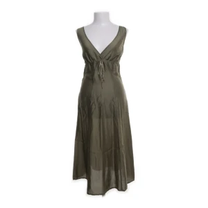 Olivgrön långklänning med v-ringning - Snygg olivgrön långklänning i glansigt material med djup v-ringning både fram och bak. Köpt på sellpy men aldrig använd, materialet är lite satinliknande men ganska tunt och blir lätt genomskinligt