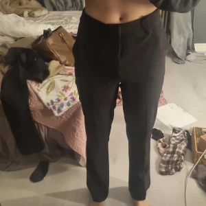 Svarta kostymbyxor från BikBok, stl 36 - Snygga svarta kostymbyxor från BikBok i storlek 36. Säljer då de tyvärr är för korta för mig som är 172 cm. Byxorna är högmidjade med raka ben och har klassisk passform. Perfekta för en clean och stilren look. Materialet känns mjukt och följsamt, och de har diskreta fickor framtill.