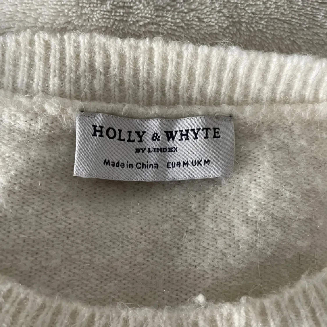 Vit stickad tröja med svart rosett - 1