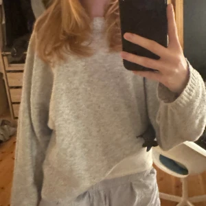 Ljusgrå stickad tröja från Nelly - Mysig ljusgrå stickad tröja med rund halsringning och långa ärmar. Tröjan har en relaxed passform och ribbade muddar vid ärmslut och nederkant. Perfekt för lager-på-lager och chill dagar. Pris går alltid att diskutera💕
