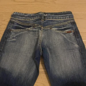 Blå bootcut jeans med slitna detaljer - Bootcut jeans från G-Lago i mörkblå tvätt med slitna och fransade detaljer vid fickor och midja. Omsydda längst ner på byxbenet för bättre passform. (Missfärgning på ena låret och vid midjan fram och bak som knappt märks) Midjemått 34cmx2 Innebenslängden 76cm och gren 17cm. Skriv gärna efter fler bilder eller mått💙 