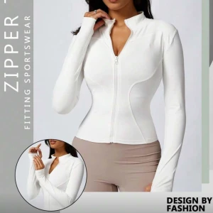 Träningströja🤍 - Säljer en vit, figurnära hoodie med dragkedja framtill och högt krage. Tröjan har långa ärmar med tumhål och markerade sömmar som framhäver midjan. 