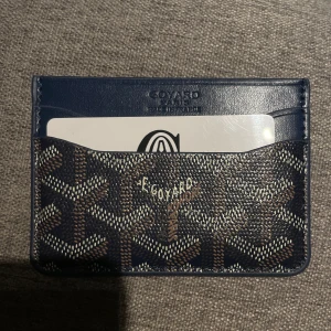 Korthållare - Säljer denna tvär feta korthållaren som är perfekt nu inför hösten. Korthållare är i färgen marinblått brunt och vitt med det klassiska mönstret. Korthållare är helt ny och box medföljer.