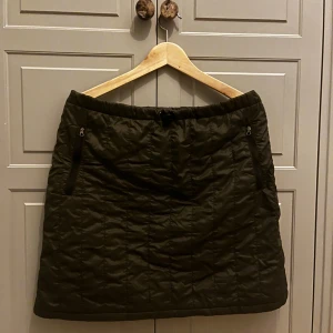 MONCLER kjol | ytterkjol - Moncler ute kjol L i mörkgrön. Kjolen har två fickor och ett reglerings band runt midjan, flis inuti.