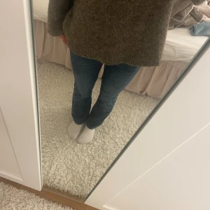 Blå bootcut jeans med låg midja - Snygga blå jeans med bootcut-modell och låg midja. Jeansen har klassisk femficksdesign, dragkedja och knapp framtill. Änvända men inget som märks. Innerbenslängd: ca 72cm, midja: 36cm. Från Gina Young. Pris kan diskuteras något