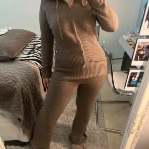 Bruna stickade byxor från NA-KD - Mysiga bruna stickat set från NA-KD i modell med lite utsvängda ben. Byxorna är i mjukt material och har en relaxed passform, perfekta för chill dagar hemma. Snyggt set tillsammans med matchande hoodie.