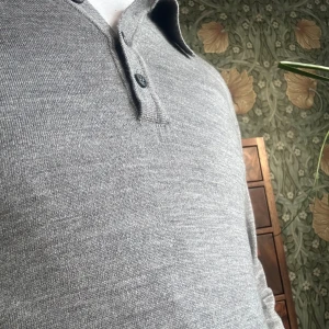 Oscar Jacobson pike - Snygg grå pikétröja från Oscar Jacobson med klassisk krage och tre knappar. Perfekt för en stilren look. Tröjan är i ett mjukt material som ger en bekväm passform. Tröjan är använd fåtal gånger. Nyskick! Nypris ligger runt 1900kr. M fast är mindre i strl så passar S