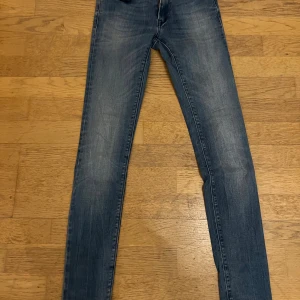 Replay LUZ skinny jeans blå 24/32 - Snygga blå skinny jeans från Replay, modell LUZ. Jeansen har klassisk femficksdesign, smal passform och subtila slitningar för en cool look. Tillverkade i stretchig denim för extra komfort. Perfekta för dig som gillar en tight och modern stil.