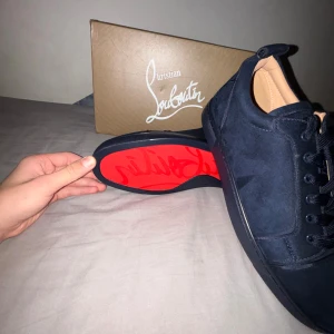 Christian Louboutin marinblå sneakers mocka - OBS dessa är köpa av en privat leverantörfrån!  Snygga mörkblå sneakers från Christian Louboutin i mocka med ikonisk röd sula och broderad logga på hälen. Skorna har rund tå, platt sula och klassisk snörning. Perfekta för dig som vill sticka ut med exklusiv stil och detaljer. Storlek 44. Äktenhetsbevis ingår samt alla andra artiklar med på bilderna. Inga defekter eller syntecken på användning därav ett pris på 2199!!