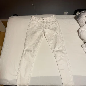 Vita skinny jeans med låg midja - Snygga vita jeans med smal passform och mellan hög midja. Dragkedja och knapp framtill. Perfekta för dig som gillar en clean och fräsch look. Materialet är mjukt och stretchigt för extra komfort.