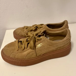 Puma Suede sneakers i beige mocka - Säljer ett par Puma Suede sneakers i beige mocka med matchande snörning och bruna gummisulor. Klassisk låg modell med rund tå och diskret guldfärgad Puma-logga på sidan. Använd 2 gånger
