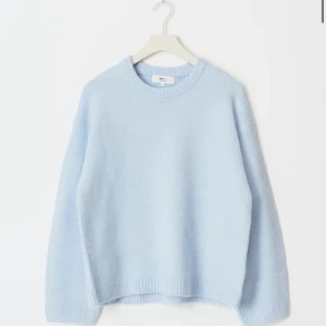 Ljusblå stickad tröja från Gina Tricot - mysig ljusblå stickad tröja från Gina Tricot i ullblandning. Tröjan har rund hals, ribbade muddar och  en loose passform.