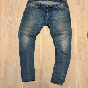 Tvärgoa Nudie jeans i ljusblå med feta slitningar, storlek w38 - Riktigt sjyssta Nudie jeans med en super fet tvätt! Otroligt bra skick på dessa finns inga tecken på användning vid skrevet eller liknande! Stolek W38 frågor om mått eller liknande så är det bara att skicka!