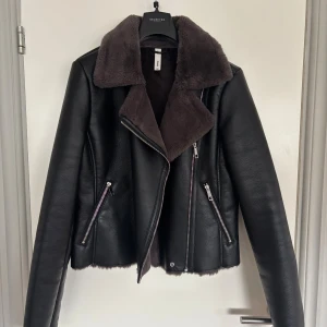 Svart skinnjacka med grå/ brun päls  - Svart skinnjacka från Mango med superskön päls inuti vilket gör den varm och go. Tyvärr för liten för mig… Den är mer som S/M i storlek… väldigt lite använd!