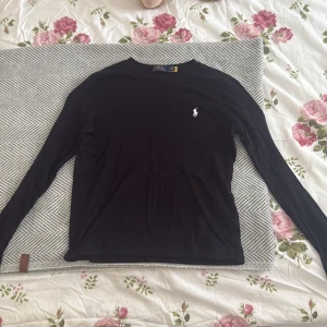 Svart långärmad tröja från Polo Ralph Lauren - Svart långärmad tröja från Polo Ralph Lauren med en vit broderad logga på bröstet 