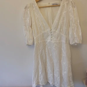 Vit blommig kortklänning från Adoore - Superfin vit kortklänning från Adoore med broderade blommor, v-ringning och markerad midja! Perfekt till studenten. Nypris 1499kr, storlek 40 men sitter som S/M. Mer åt M hållet!