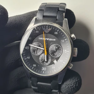 Emporio Armani AR5858 - Nypris - 2500 SEK  Okej skick (se bilder), fungerar felfritt. En del mikrorepor på glaset och armbandet är något slitet på undersidan.  Batteribyte någon månad sedan.  Diameter: 43 mm  Armband passar ~16-17cm Inga extra länkar medföljer tyvärr