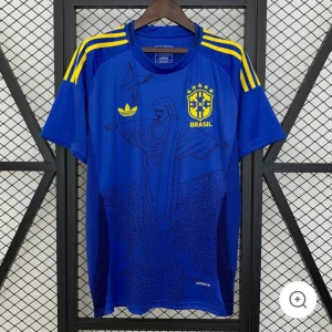 Blå Brasilien fotbollströja Adidas M - Snygg blå Brasilien fotbollströja från Adidas med gula detaljer och tryck av Kristusstatyn på framsidan. Tröjan har gula ränder på axlarna, CBF-logga och Adidas-märke på bröstet. Tillverkad i lätt och ventilerande material, perfekt för match eller träning.