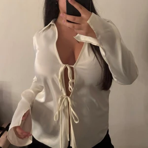 Satin skjorta  - Så fin skjorta med knytdetaljer och slits i ärmarna.  Strlk S