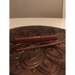 CAIA läppenna Bianca brun - Snygg läppenna från CAIA i nyansen Bianca, en varm brun färg. Pennan har klassisk träform och kommer i originalförpackning. Perfekt för att definiera läpparna och skapa en fylligare look.