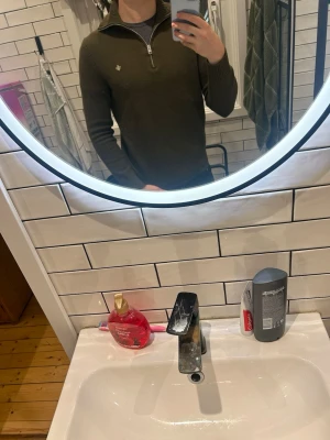 Olivgrön half zip tröja Morris S - Olivgrön stickad tröja från Morris i storlek S, tillverkad i 100% merinoull. Tröjan har en ribbad hög krage och half zip-dragkedja framtill. Liten broderad logga på bröstet och ribbade muddar vid ärmslut och nederkant. Perfekt för dig som gillar stilrena och bekväma plagg. Sitter mycket bra på mig som är 184. Men den passar även några cm kortare och några cm längre. Nypris ligger runt 1200. Ej använd utan den har bara legat hemma.