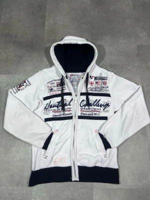 vintage Geographical Norway zip-up hoodie - Säljer en vintage Geographical Norway zip-up hoodie i snygg vit färg. 🧵 Märke: Geographical Norway 👕 Storlek: M 🎨 Färg: Vit 📌 Design: Zip-up hoodie i klassisk Y2K-stil 📍 Skick: Mycket bra, se bilder!  Beskrivning: • Äkta Y2K-stil från Geographical Norway • Zip-up modell med huva – praktisk och stilren • Bekväm och varm, perfekt för vardag och layering • Inga fläckar, noppor eller skador (kontrollera bilder) • Lätt att matcha med jeans, cargos eller mjukisbyxor